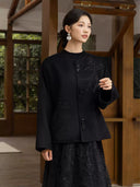 Front view of the Nanqiao coat showing its round neckline, botanical embroidery and three tassel fastenings.