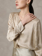 Tie neckline detail on a champagne silk blend blouse
