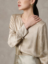 Tie neckline detail on a champagne silk blend blouse