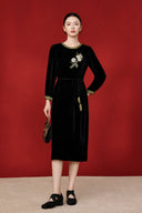 Full-length front view of a model wearing the black velvet midi dress