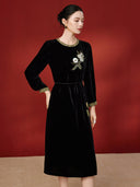 Angled view of the black velvet dress showing its A-line shape and embellished bodice