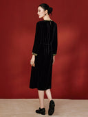 Back view of the dress on a model, showing the velvet drape and waist tie