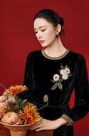 Model wearing the black velvet midi dress, showing the floral sequin motif and patterned neckline
