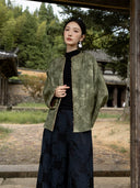 Front view of an olive floral jacket showing its open front, relaxed shape, wide sleeves and decorative edging.
