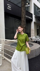 Woman in an olive green New Chinese style top with short sleeves, highlighting the breathable viscose-nylon material and elegant silhouette.
