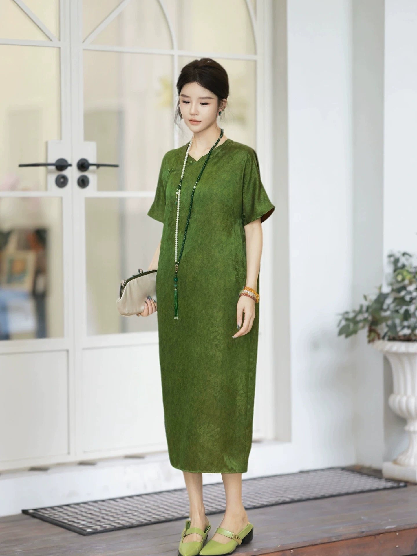 Model wearing an olive green 100% mulberry silk new Chinese dress with a stand collar