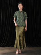 Front view of the olive green pleated fishtail skirt with a soft glossy finish and A-line silhouette