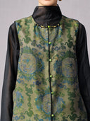 Close-up of the beaded round neckline, green buttons and black piping