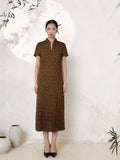 Full body shot of an olive green silk Cheongsam dress with a mandarin collar, V-slit neckline, short sleeves, and a geometric jacquard pattern, crafted from 100% mulberry silk, midi length with a straight A-line silhouette.