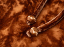 Close-up of the copper-orange dress’s self-tie belt ends