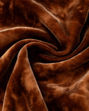 Close-up of the copper-orange dress’s softly lustrous fabric texture
