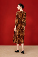 Back view of the copper-orange midi dress on a model