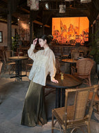 Modern Chinese-inspired embroidered linen blend blouse styled for everyday elegance in a café.