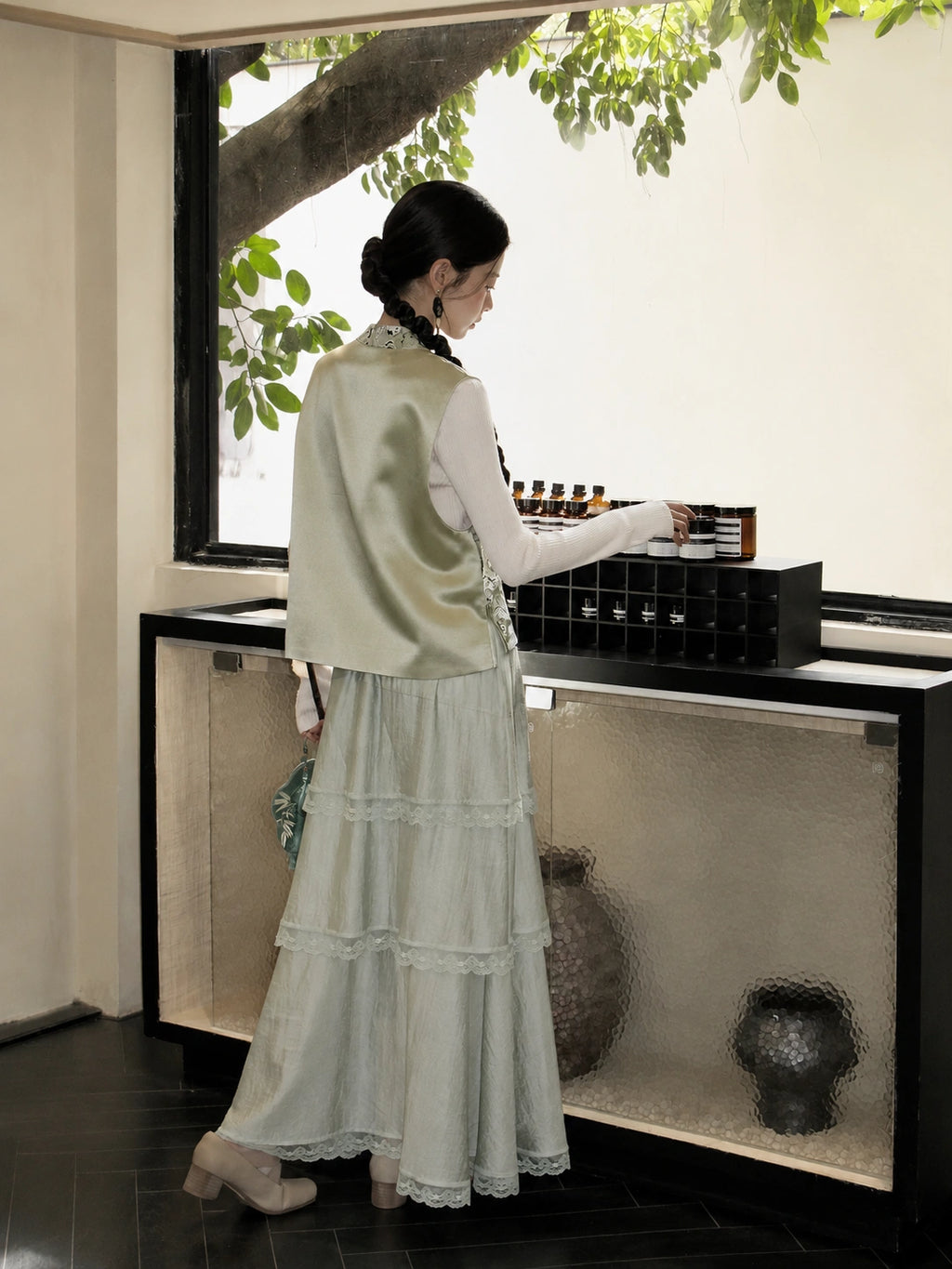 Back view of a pale green Shu Jin silk Chinese vest with a stand collar and soft satin finish.