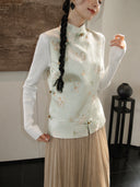 Close-up of a pale mint mulberry silk vest showing its cat and butterfly pattern, stand collar, and decorative knot buttons.