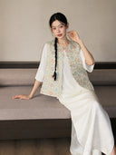 Close-up of a pastel floral Chinese-style vest featuring a round neckline and button front.