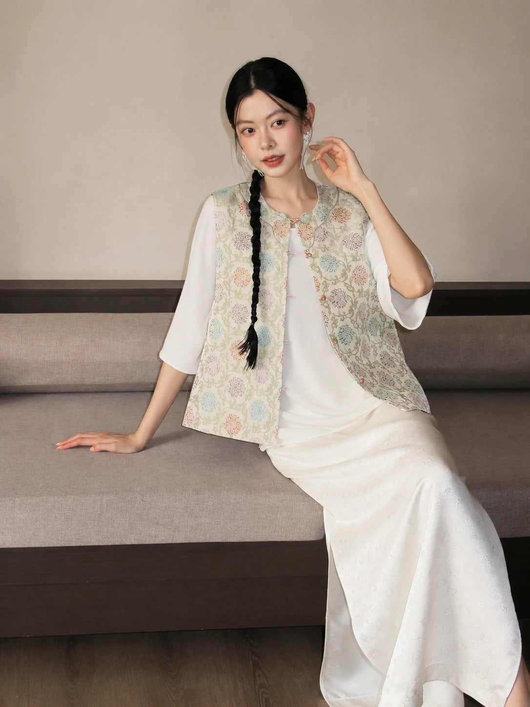 Close-up of a pastel floral Chinese-style vest featuring a round neckline and button front.