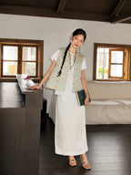 Full-body view of a pastel floral Songjin silk vest styled with an ivory long skirt.