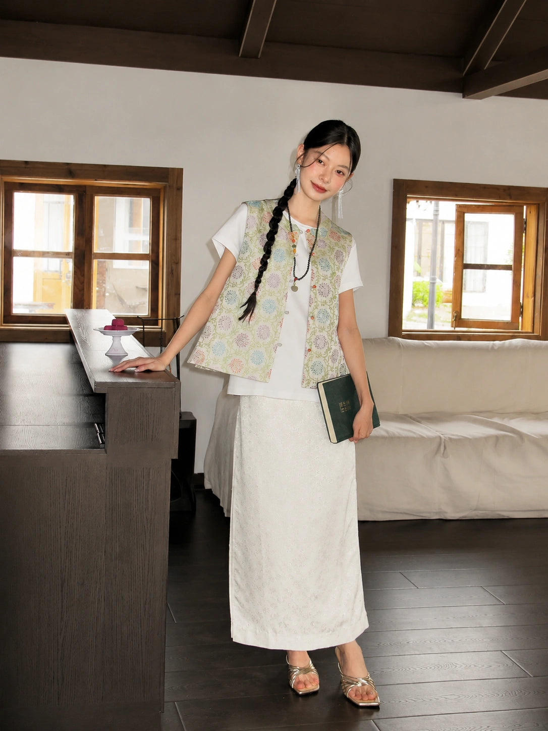 Full-body view of a pastel floral Songjin silk vest styled with an ivory long skirt.