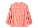 Back view of a peach pink printed blouse with puff sleeves and a keyhole neckline