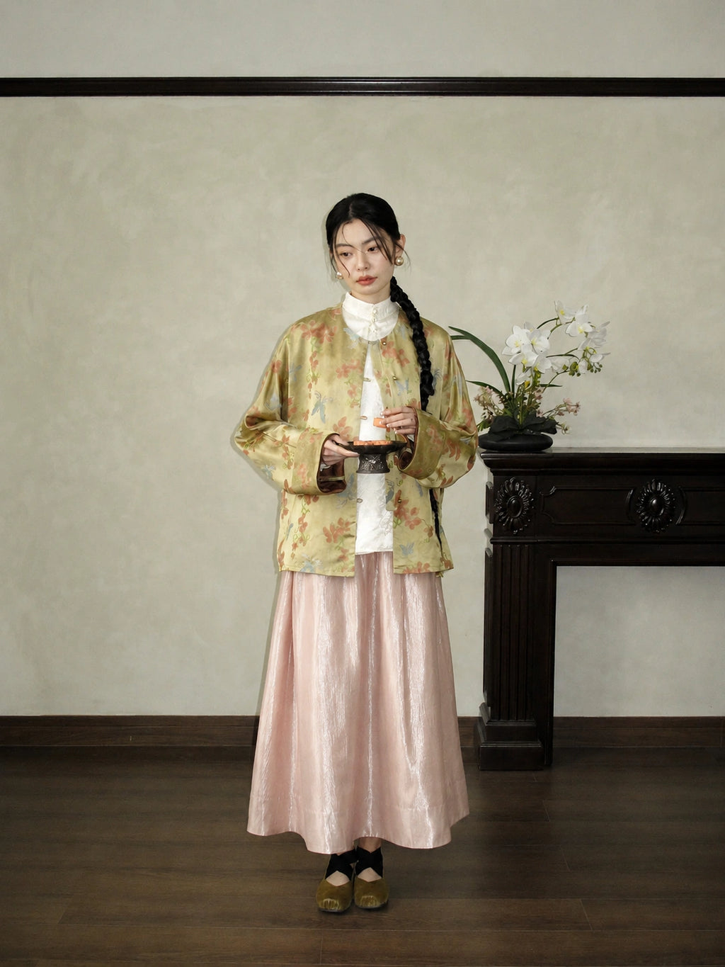 Full-body outfit featuring a pink high-waist A-line skirt styled with a white blouse and floral jacket for an elegant commuter look.