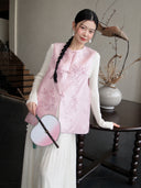 Close-up of a pink Chinese-style silk vest showing its floral jacquard texture, round neckline, and traditional knot buttons.