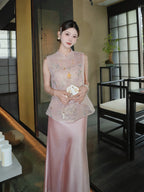 Front view of a pink Cheongsam vest with floral sequin embroidery, paired with a pink satin skirt, standing in a traditional interior setting.