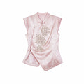 Flat lay of a pink cap-sleeve Cheongsam top with a mandarin collar, silver sequin floral embroidery, and an asymmetric hem.