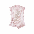 Flat lay of a pink cap-sleeve Cheongsam top with a mandarin collar, silver sequin floral embroidery, and an asymmetric hem.