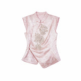 Flat lay of a pink cap-sleeve Cheongsam top with a mandarin collar, silver sequin floral embroidery, and an asymmetric hem.