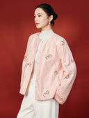 Model showing the pink jacket’s long sleeves, smooth turn-back cuffs and embroidered butterfly details.