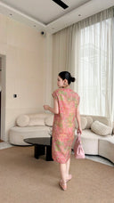 Back view of a pink watercolor Cheongsam dress with a textured jacquard pattern, paired with a matching pink handbag.