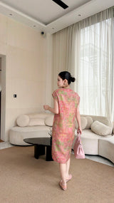 Back view of a pink watercolor Cheongsam dress with a textured jacquard pattern, paired with a matching pink handbag.