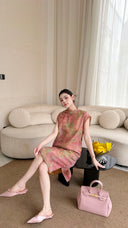 Woman sitting on a sofa in a pink sleeveless Cheongsam dress, holding a pink bag, highlighting the elegant drape of the Lyocell-linen material.