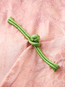 Close-up of the contrasting green frog-button closure on a pink floral Chinese-style blouse.