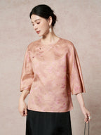 Side view of a pink-gold silk blouse with a relaxed fit and side button details, showcasing the luxurious 100% mulberry silk fabric.