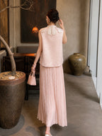 Back view of a pink sleeveless Cheongsam vest with a pearl-trimmed collar, paired with a pleated skirt, highlighting the intricate jacquard pattern.