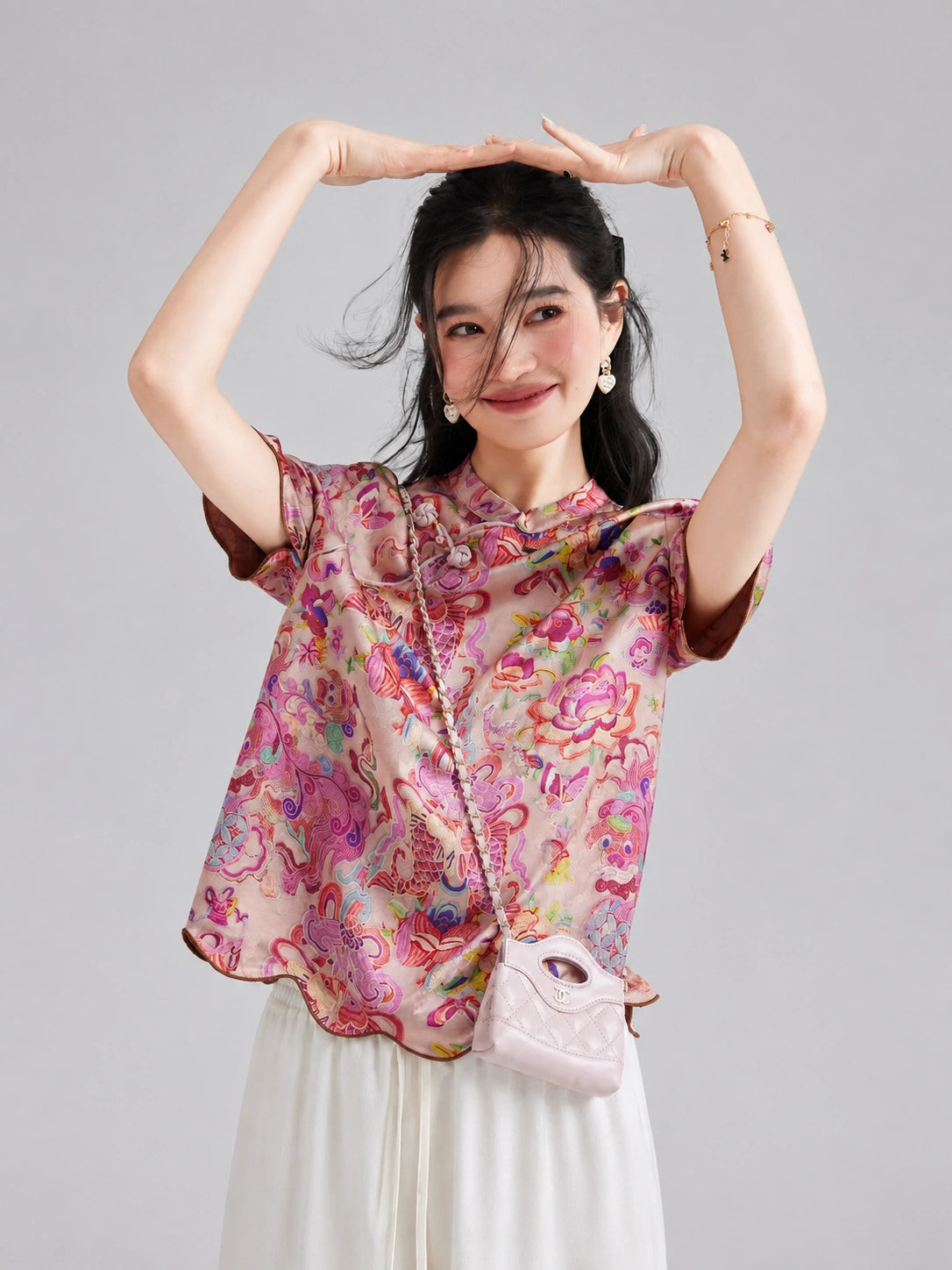 Woman styling the pink New Chinese Xiangyunsha short-sleeve top for a youthful summer look