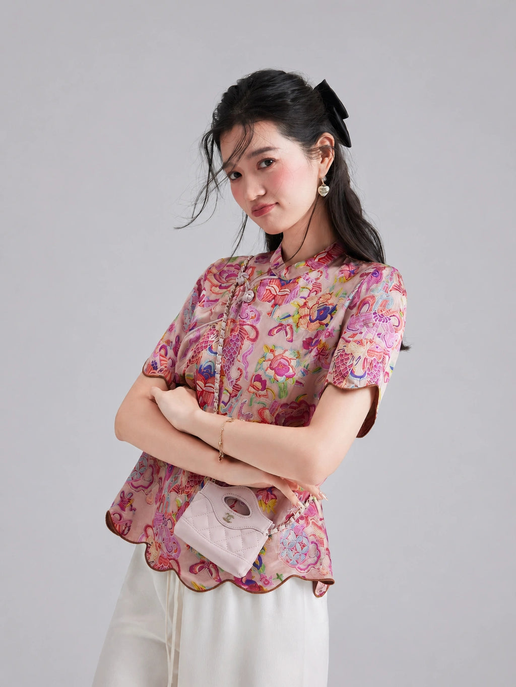 Side view of the pink Xiangyunsha top featuring colorful koi motifs and a scalloped hem
