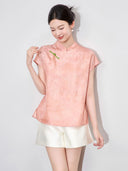 Model wearing a pink floral viscose blouse with a Mandarin collar, asymmetrical front and green frog-button detail.