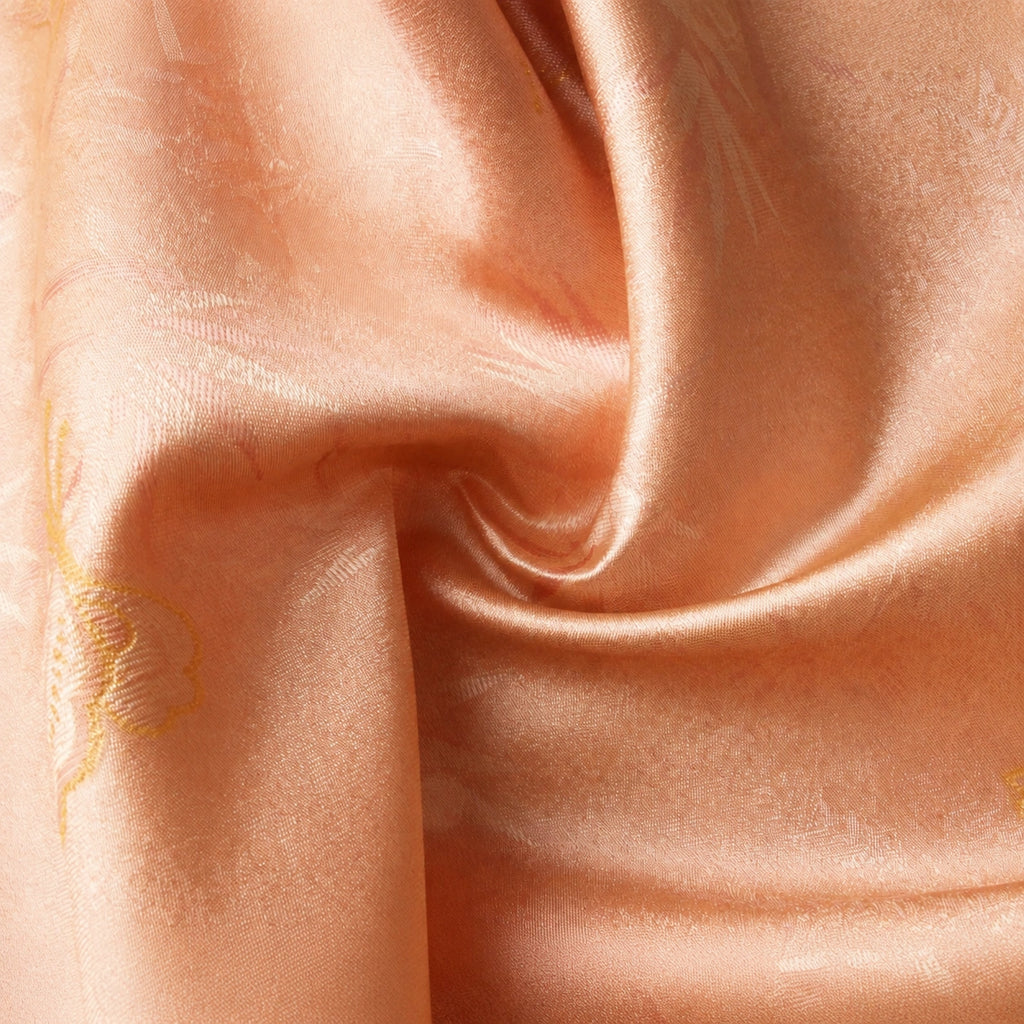 Close-up detail of pink mulberry silk fabric with subtle jacquard texture and elegant woven pattern