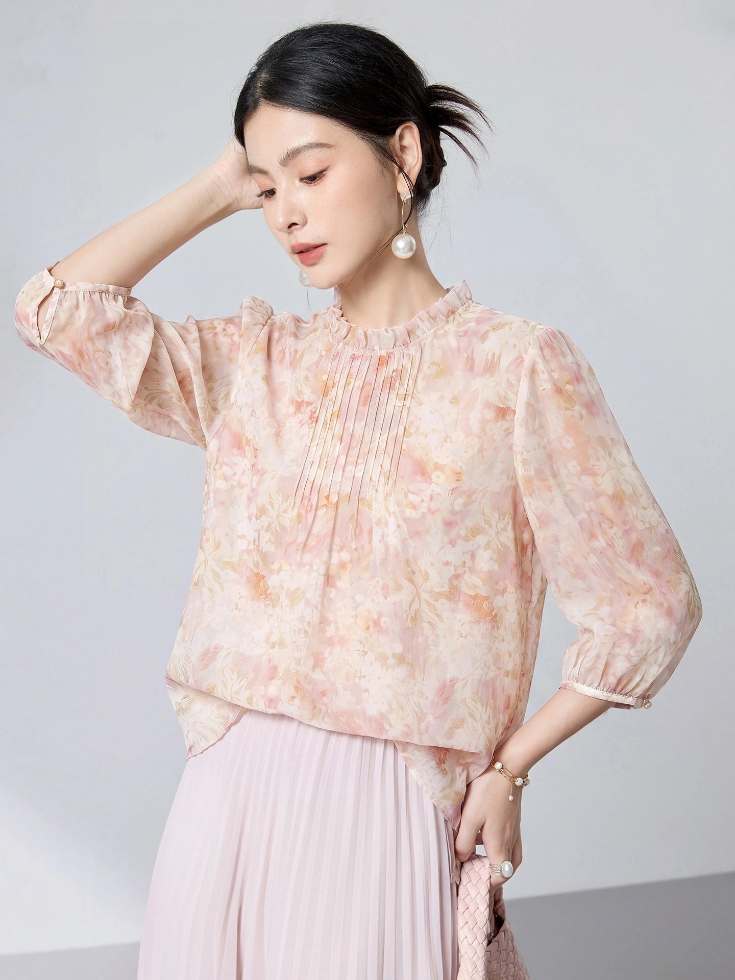 Side view of a 100% mulberry silk blouse with three-quarter puff sleeves and a floral print, highlighting the elegant drape and refined texture.