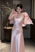 Model wearing a pink satin slip dress with a matching sheer jacket over her shoulders, featuring gold-tone strap hardware, 100% polyester fabric.