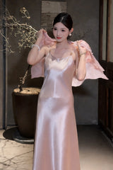 Model wearing a pink satin slip dress with a matching sheer jacket over her shoulders, featuring gold-tone strap hardware, 100% polyester fabric.