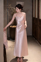 Full body shot of a pink satin slip dress with delicate spaghetti straps and a gentle cowl neckline, styled with open-toe sandals.