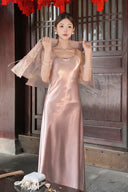 Close-up of a pink satin dress with a sheer pink jacket draped over the shoulders, highlighting the soft drape of the 100% polyester fabric.