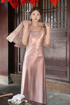 Close-up of a pink satin dress with a sheer pink jacket draped over the shoulders, highlighting the soft drape of the 100% polyester fabric.