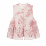 Flat lay of a pink sheer sleeveless vest with a round neckline, gold buttons, and all-over floral embroidery, 100% polyester.