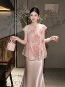 Side view of a pink translucent vest with floral embroidery and a flowing A-line silhouette, holding a pink handbag.