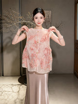 Model wearing a pink sheer sleeveless vest with gold buttons and intricate embroidery, adjusting the front closure.